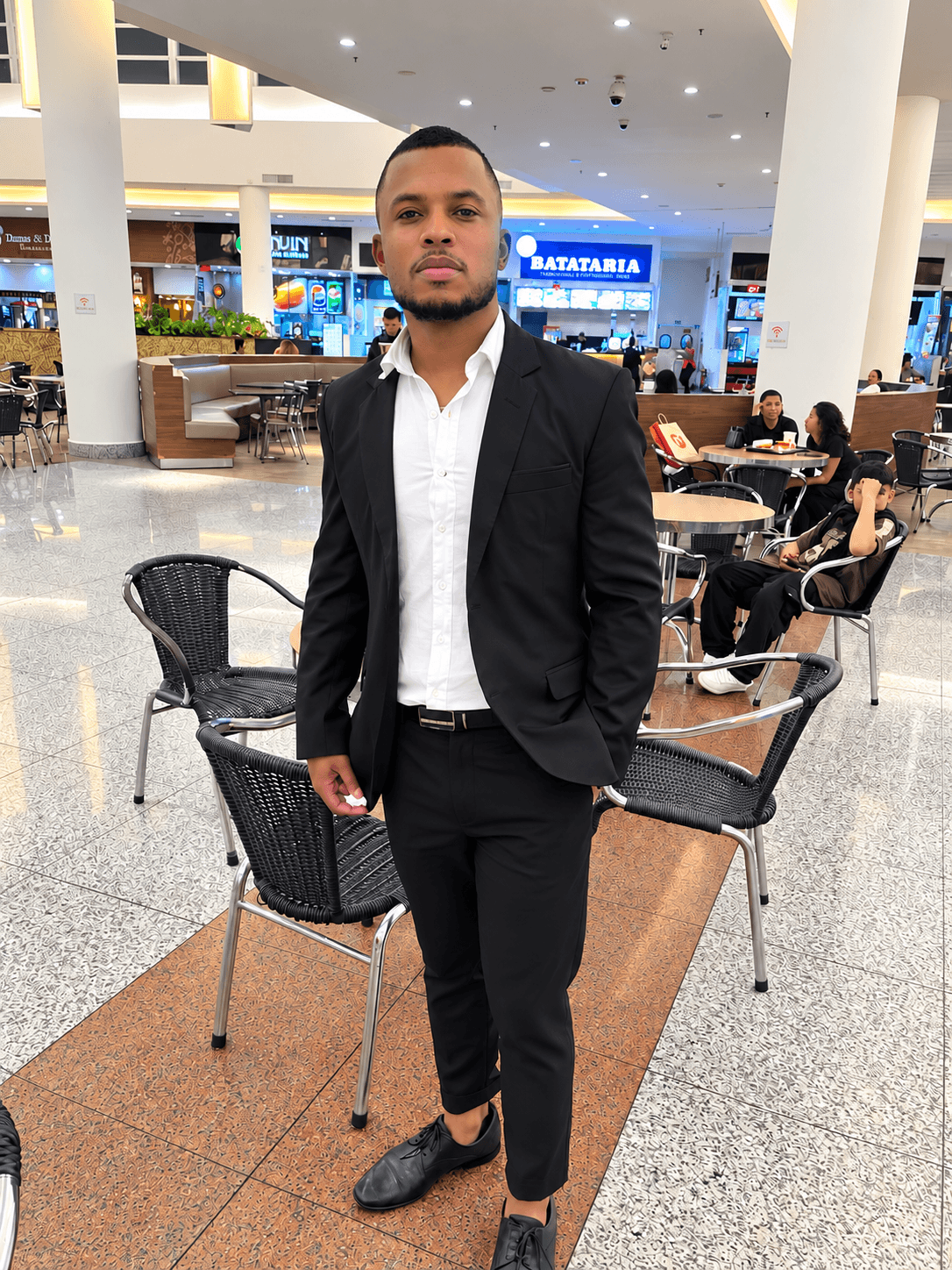 Alisson Caetano realizando um atendimento de cuidados capilares na barbearia